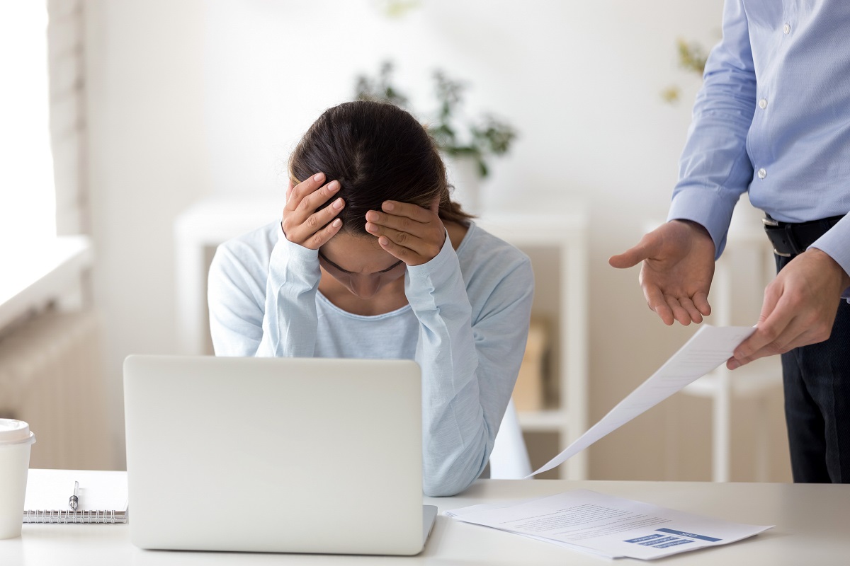 Boss accusing office worker showing mistakes in report