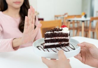 Beauty slim female body confuse chocolate cake. Woman in restaur