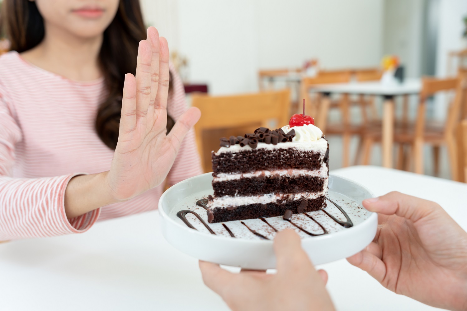 Beauty slim female body confuse chocolate cake. Woman in restaur